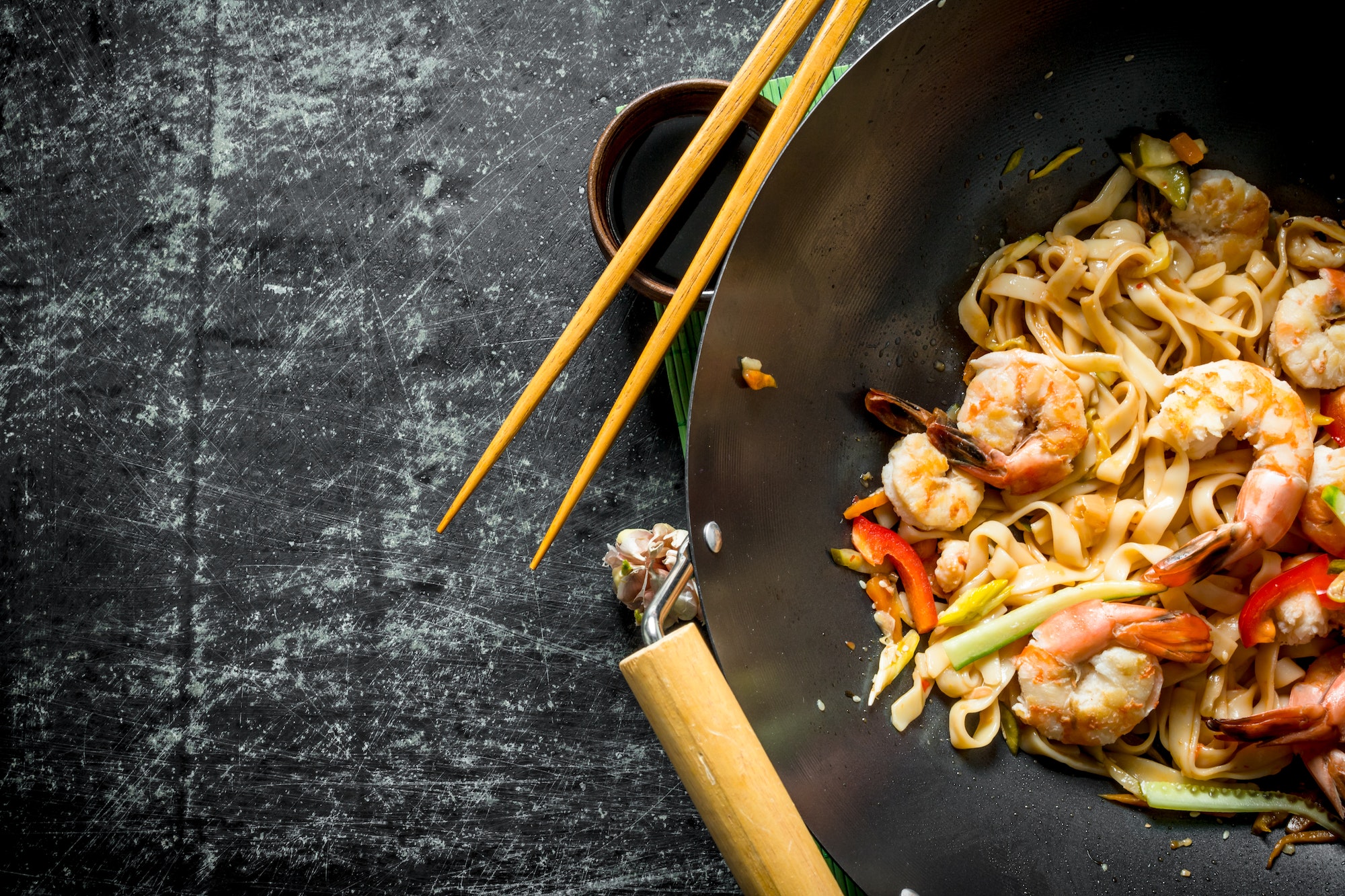 Chinese wok. Udon noodles in a wok pan with shrimp and sauce.