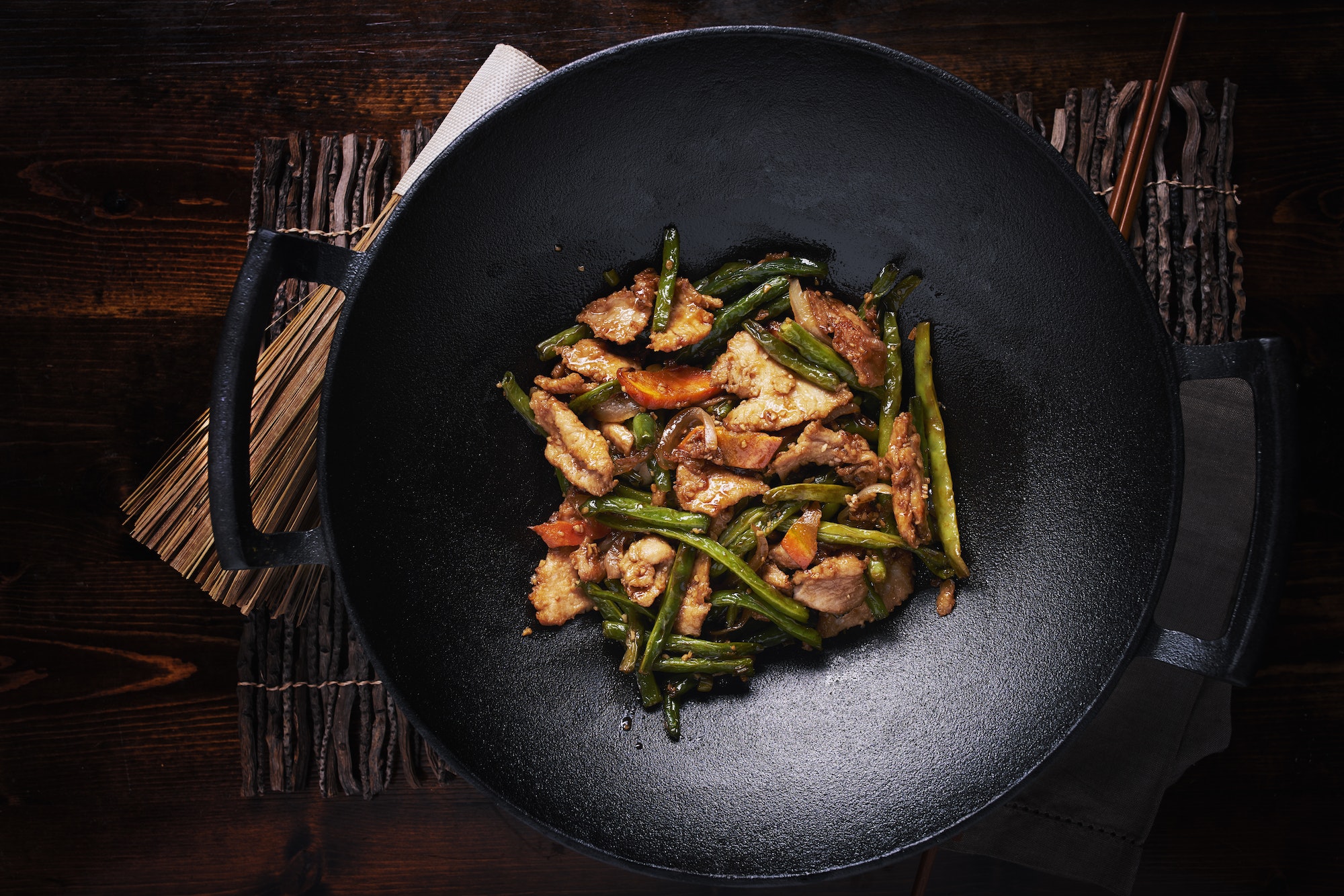 stir fried chicken in cast iron wok in flat lay composition
